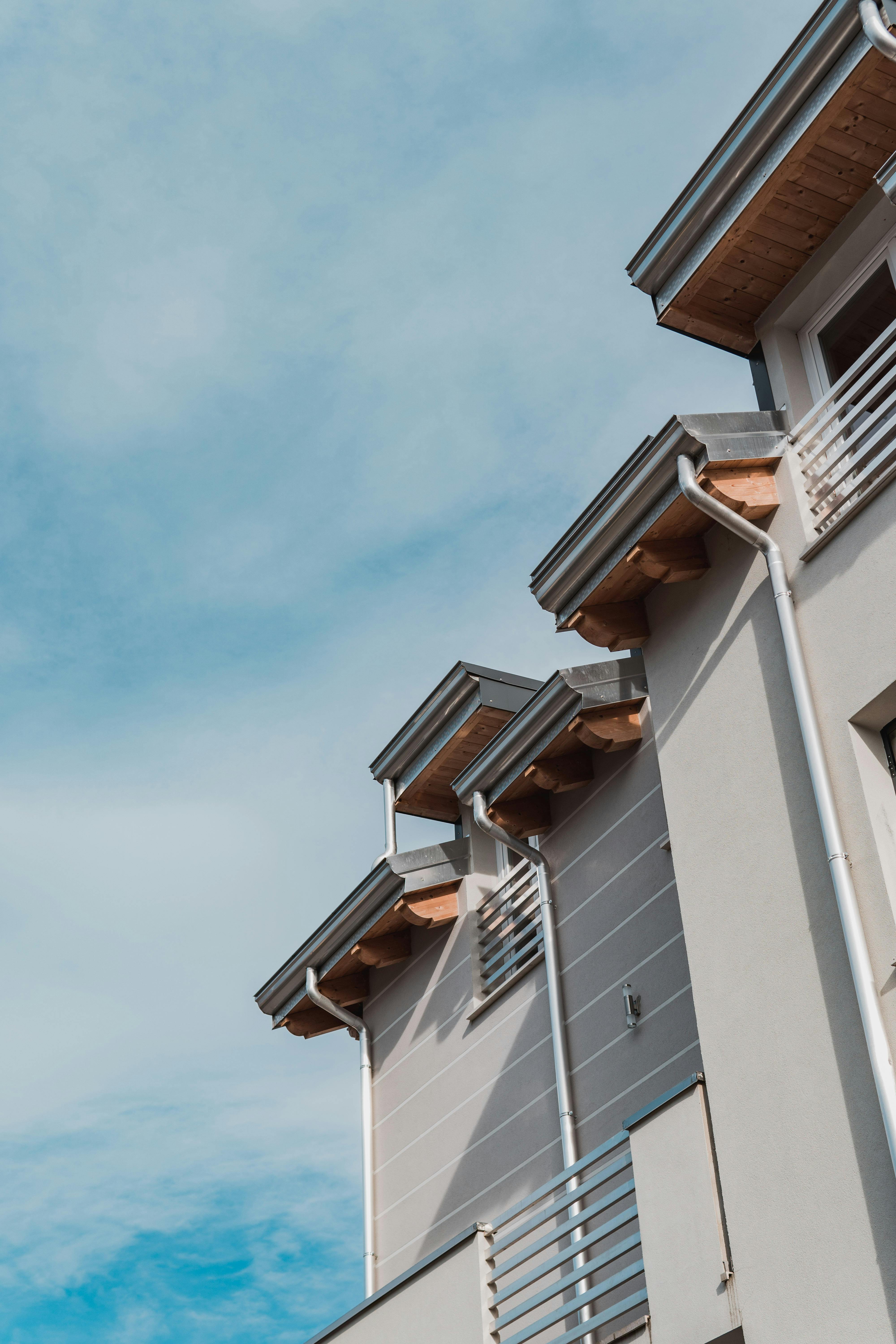 Modern home exterior with seamless metal gutters, downspouts, and gray siding